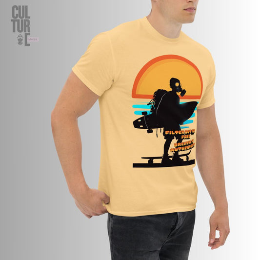 Vista lateral de un modelo llevando la camiseta urbana color arena con la ilustración de un surfer con máscara de gas y tabla de surf bajo el sol.