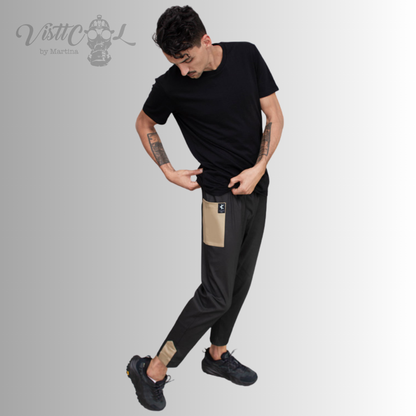 Vista de cuerpo completo del modelo combinando el pantalón funcional negro Taitsu con camiseta oscura y zapatillas deportivas.