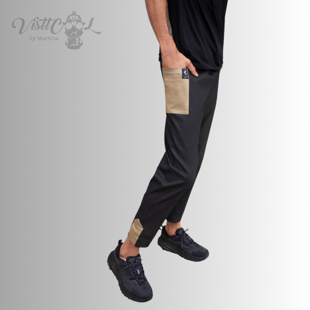 Vista de cuerpo completo del modelo combinando el pantalón funcional negro Taitsu con camiseta oscura y zapatillas deportivas.
