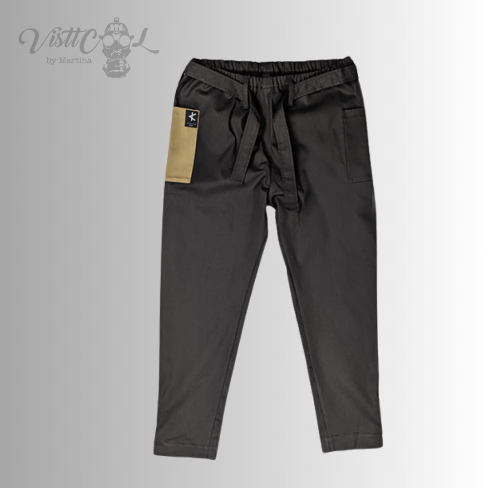Vista frontal plana del pantalón urbano unisex Taitsu en color negro, mostrando el cinturón de amarre y el detalle del bolsillo lateral en contraste beige.