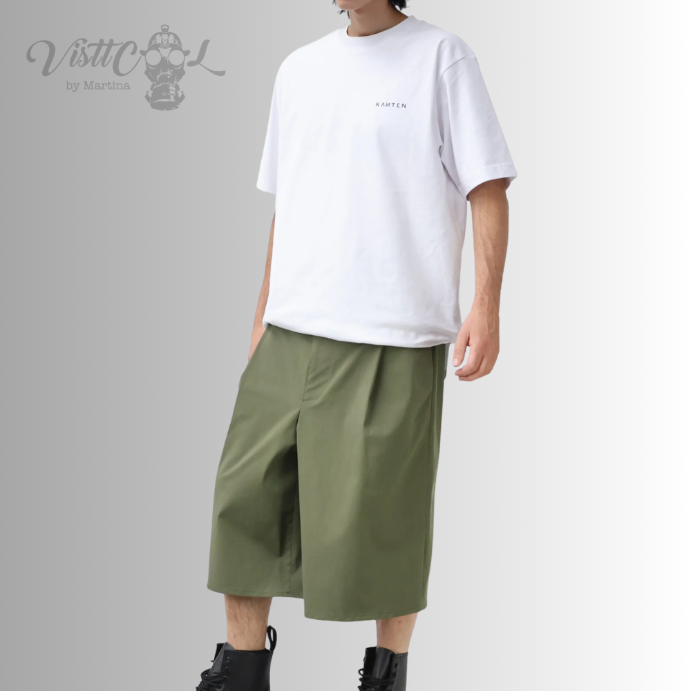 ista frontal completa de un modelo combinando las bermudas anchas inspiradas en los hakama japoneses de color verde con una camiseta blanca y botas negras.