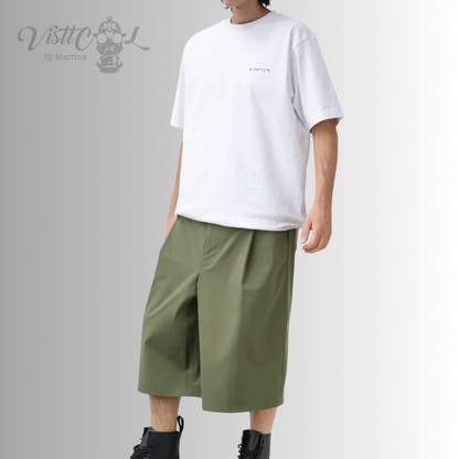 ista frontal completa de un modelo combinando las bermudas anchas inspiradas en los hakama japoneses de color verde con una camiseta blanca y botas negras.