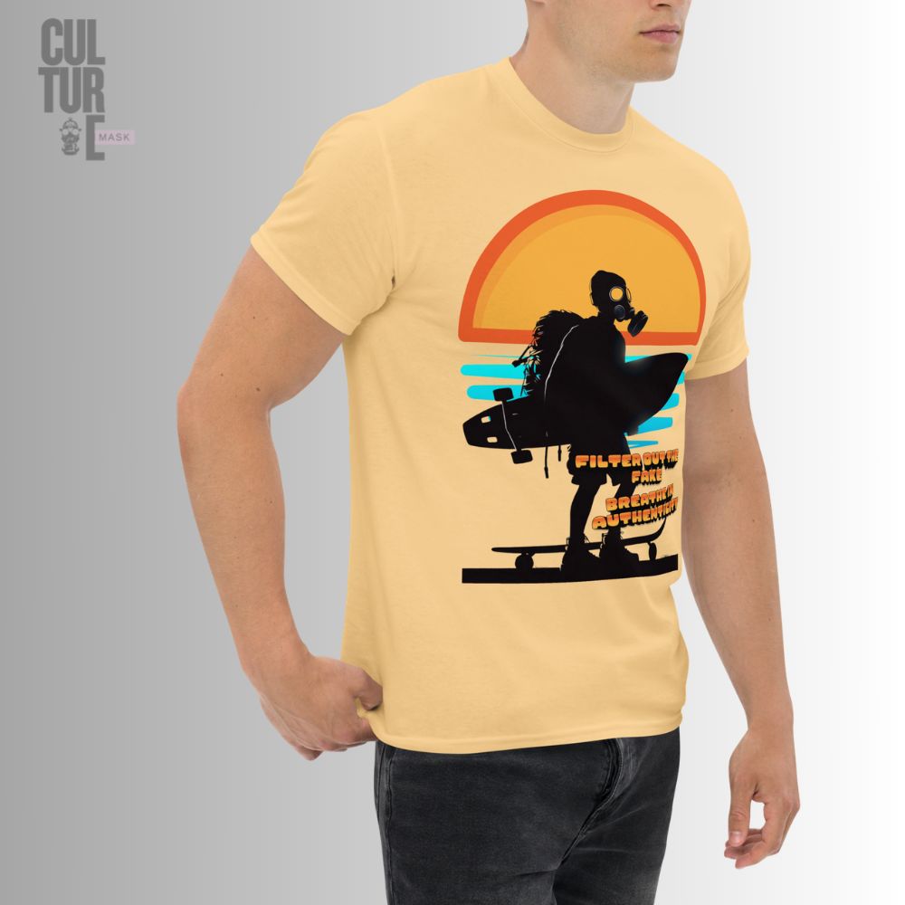 Vista lateral de un modelo llevando la camiseta urbana color arena con la ilustración de un surfer con máscara de gas y tabla de surf bajo el sol.